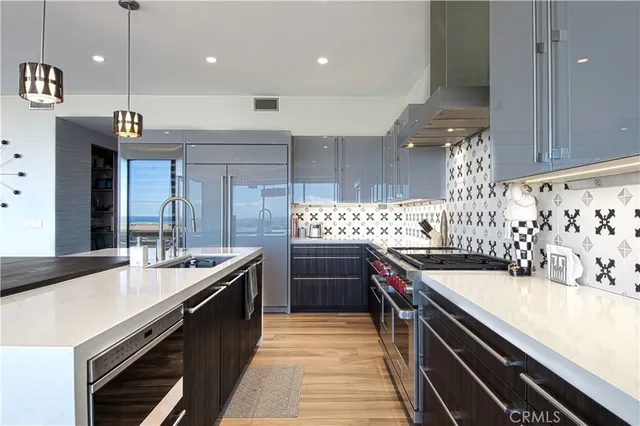 a kitchen with stainless steel appliances granite countertop a sink a stove and a wooden floors