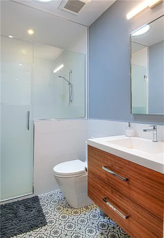 a bathroom with a sink a toilet a mirror and vanity