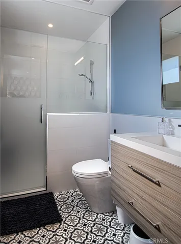 a bathroom with a sink a toilet a mirror and shower