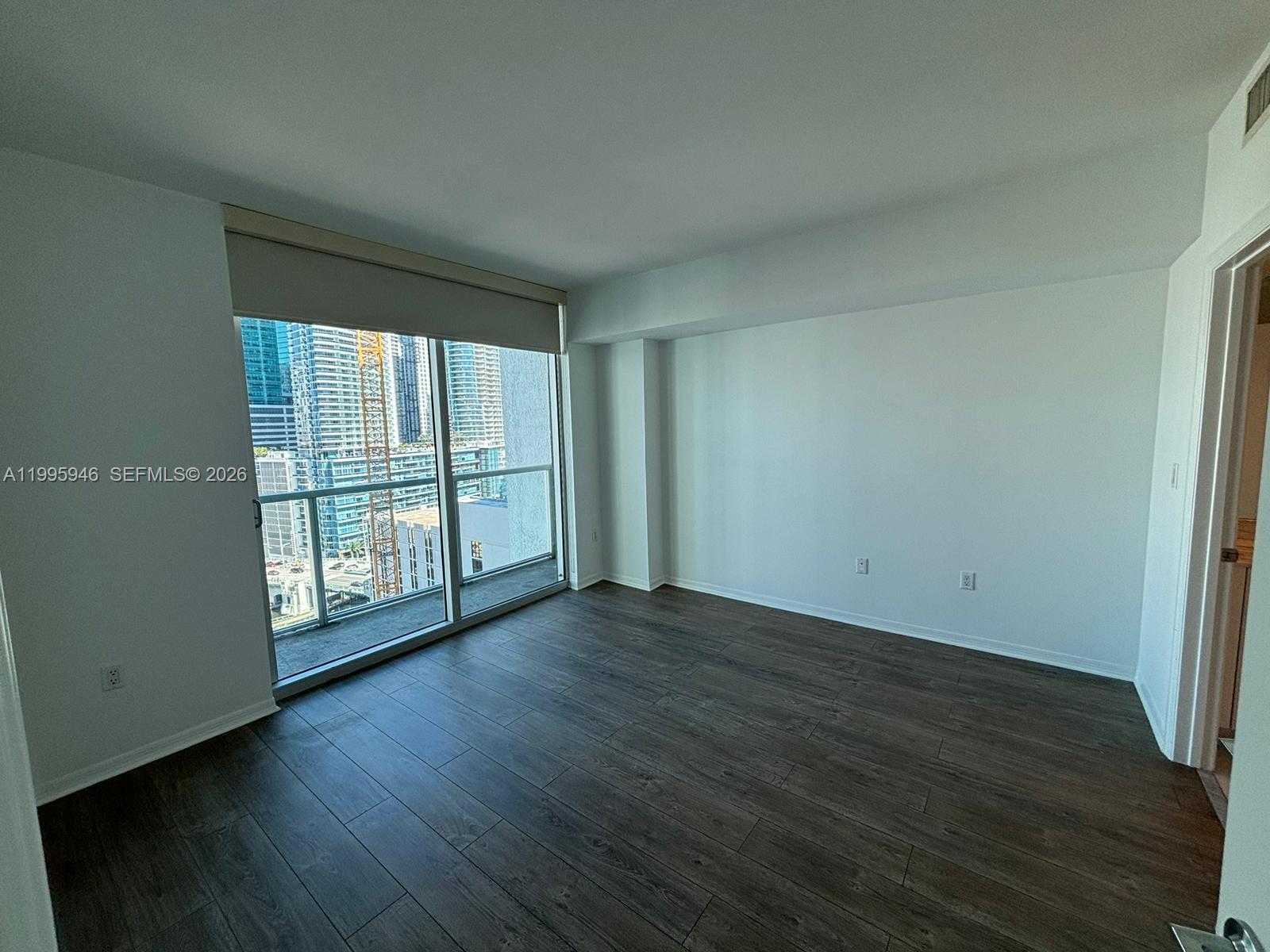 55 Southeast 6th Street, Unit 2005 Miami, FL 33131 - Photo 12 of 40 an empty room with wooden floor and windows
