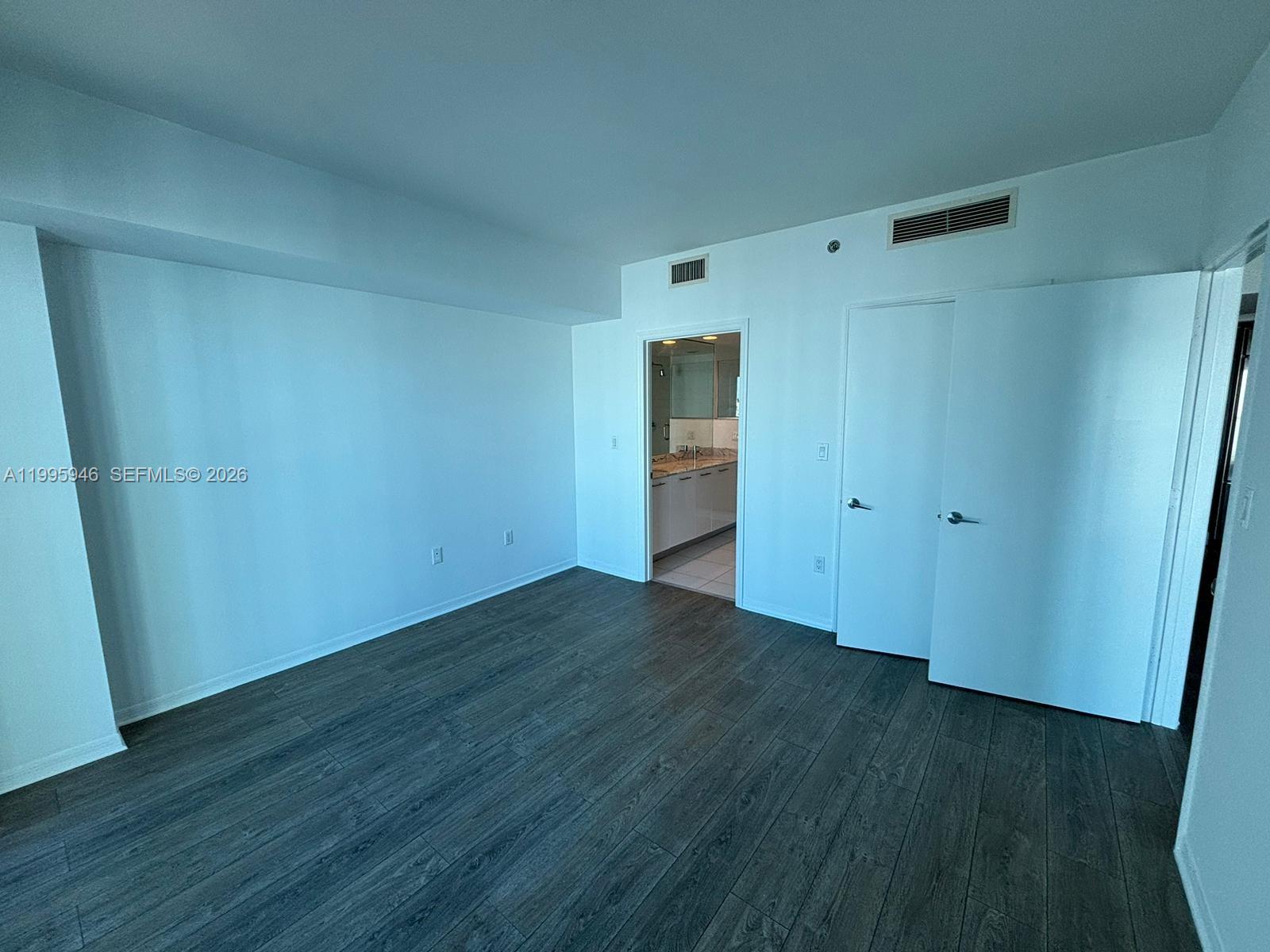 55 Southeast 6th Street, Unit 2005 Miami, FL 33131 - Photo 13 of 40 a view of an empty room with wooden floor and closet