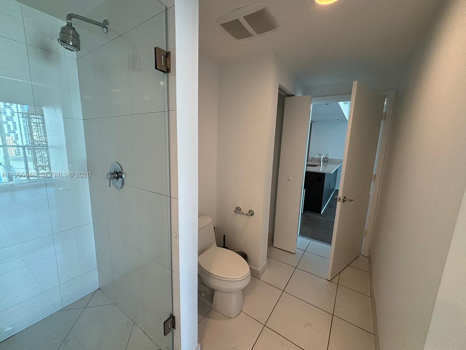 55 Southeast 6th Street, Unit 2005 Miami, FL 33131 - Photo 20 of 40 a bathroom with a granite countertop shower and a toilet