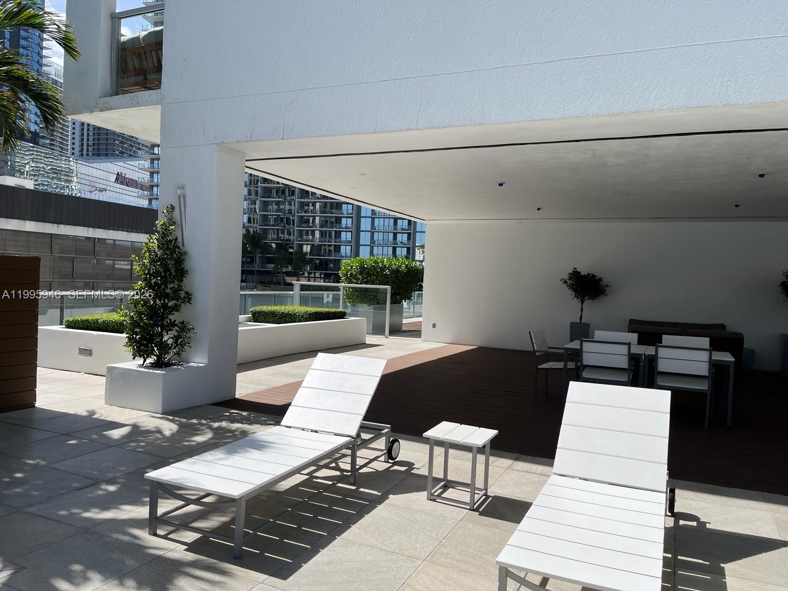 55 Southeast 6th Street, Unit 2005 Miami, FL 33131 - Photo 28 of 40 a table and chairs sitting in front of a building