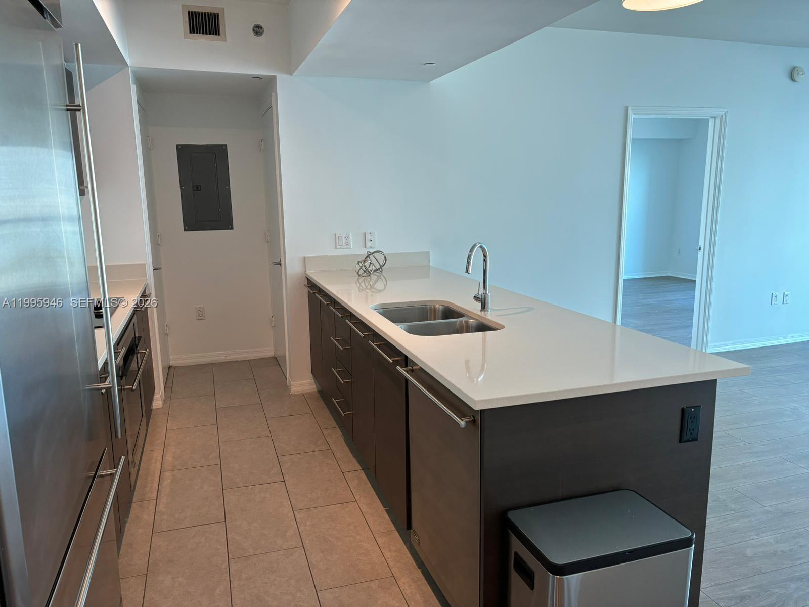 55 Southeast 6th Street, Unit 2005 Miami, FL 33131 - Photo 3 of 40 a kitchen with a sink refrigerator and microwave