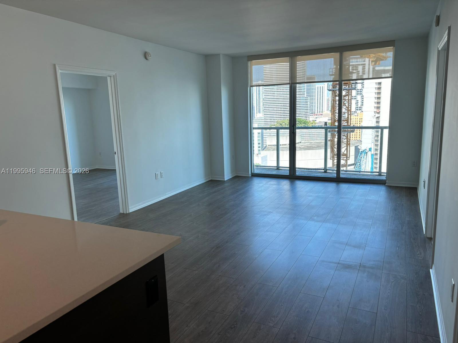 55 Southeast 6th Street, Unit 2005 Miami, FL 33131 - Photo 7 of 40 an empty room with wooden floor and windows