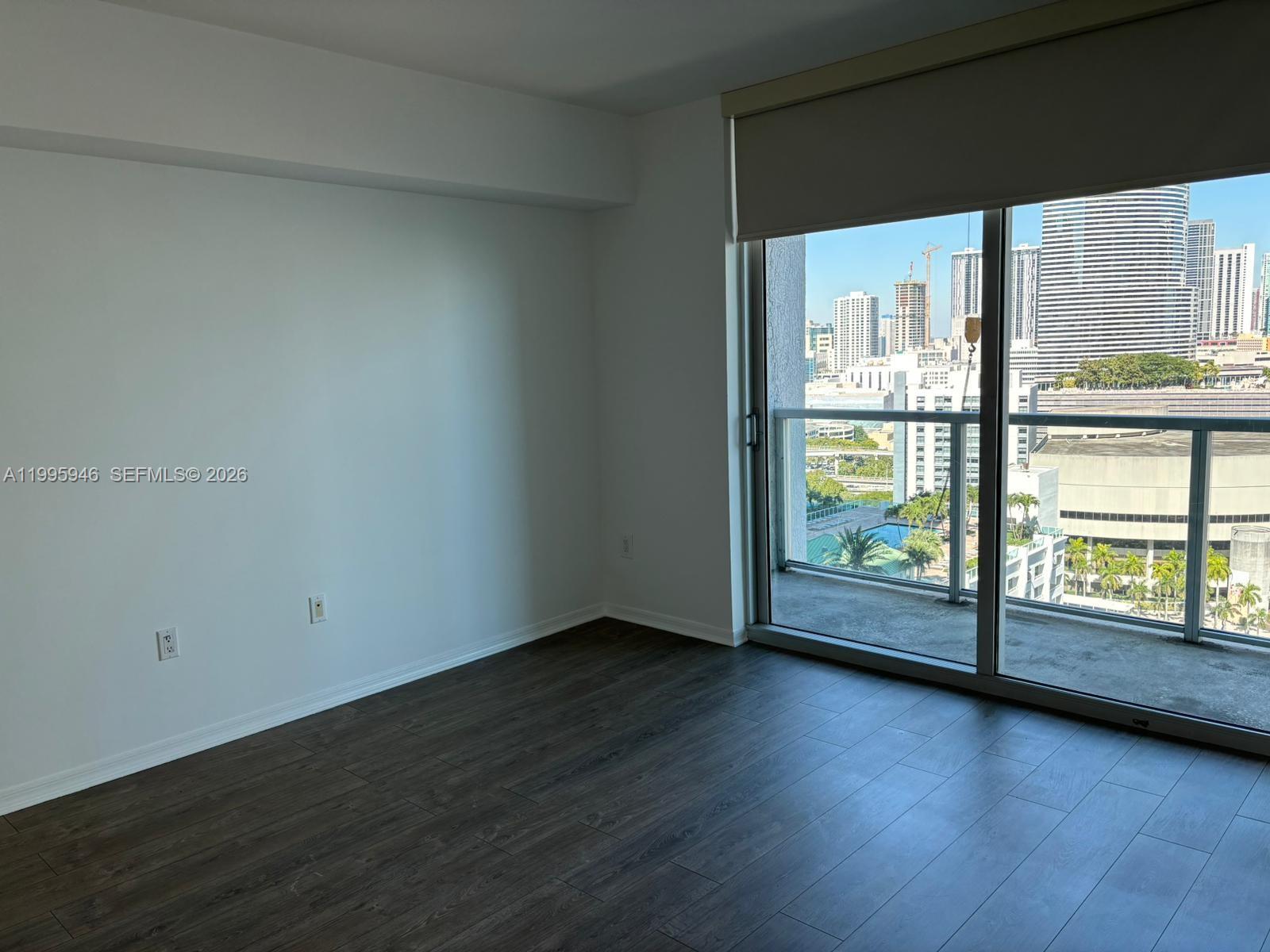 55 Southeast 6th Street, Unit 2005 Miami, FL 33131 - Photo 8 of 40 a view of an empty room with wooden floor and a window