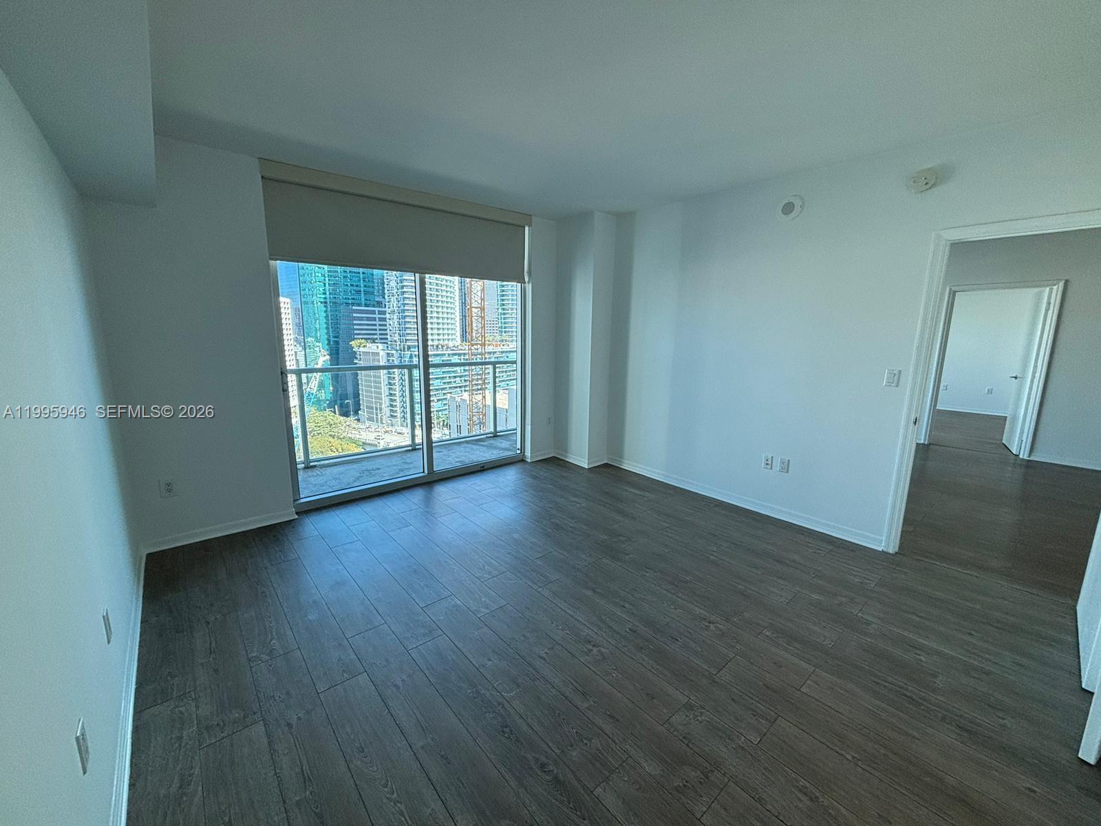 55 Southeast 6th Street, Unit 2005 Miami, FL 33131 - Photo 10 of 40 an empty room with wooden floor and sliding door