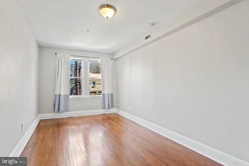 3742 12th Street Northeast, Unit 5 Washington, DC 20017 - Photo 7 of 8 an empty room with wooden floor and windows
