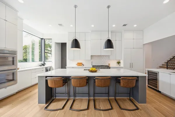 a kitchen with stainless steel appliances granite countertop a stove a sink a oven a dining table with chairs and cabinets