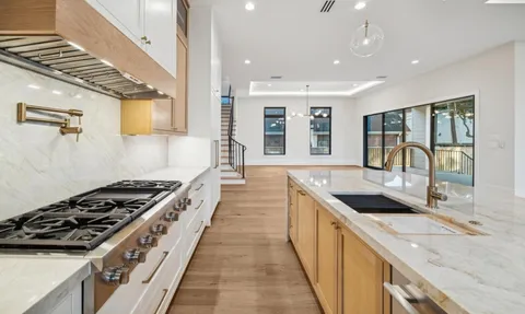 a kitchen with stainless steel appliances granite countertop a sink stove and cabinets