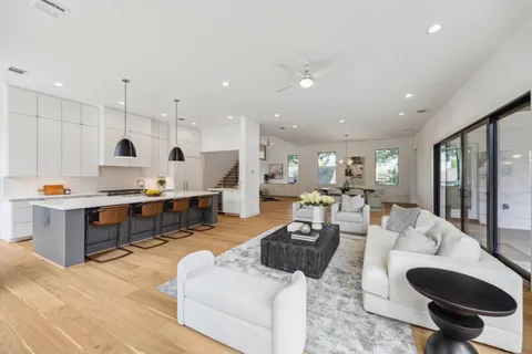 a living room with furniture kitchen view and a large window