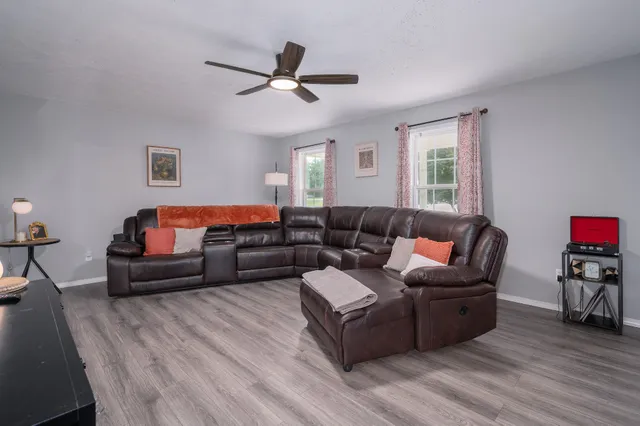 a living room with furniture and a wooden floor