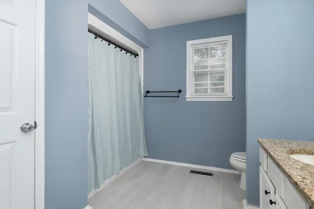 a bathroom with a granite countertop sink toilet and shower