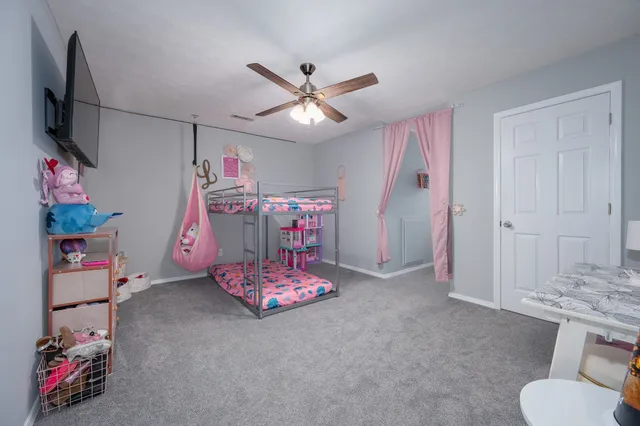 a bedroom with furniture and a chandelier fan