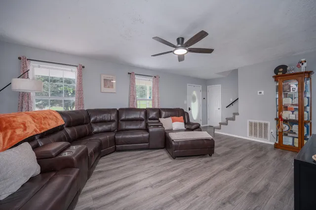 a living room with furniture and a wooden floor