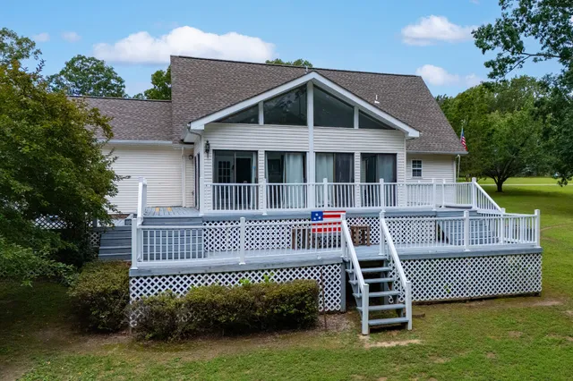 a view of a house with a deck and a yard