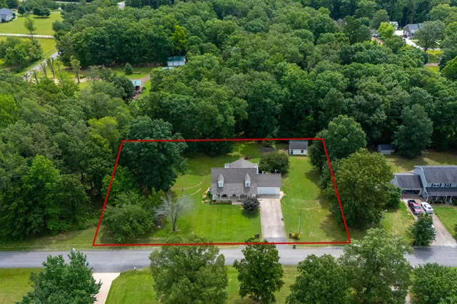 an aerial view of a house with a yard basket ball court and outdoor seating