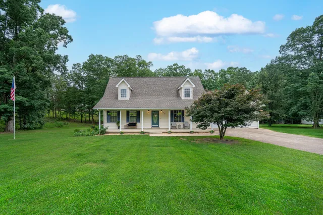 a view of a big house with a big yard and large trees