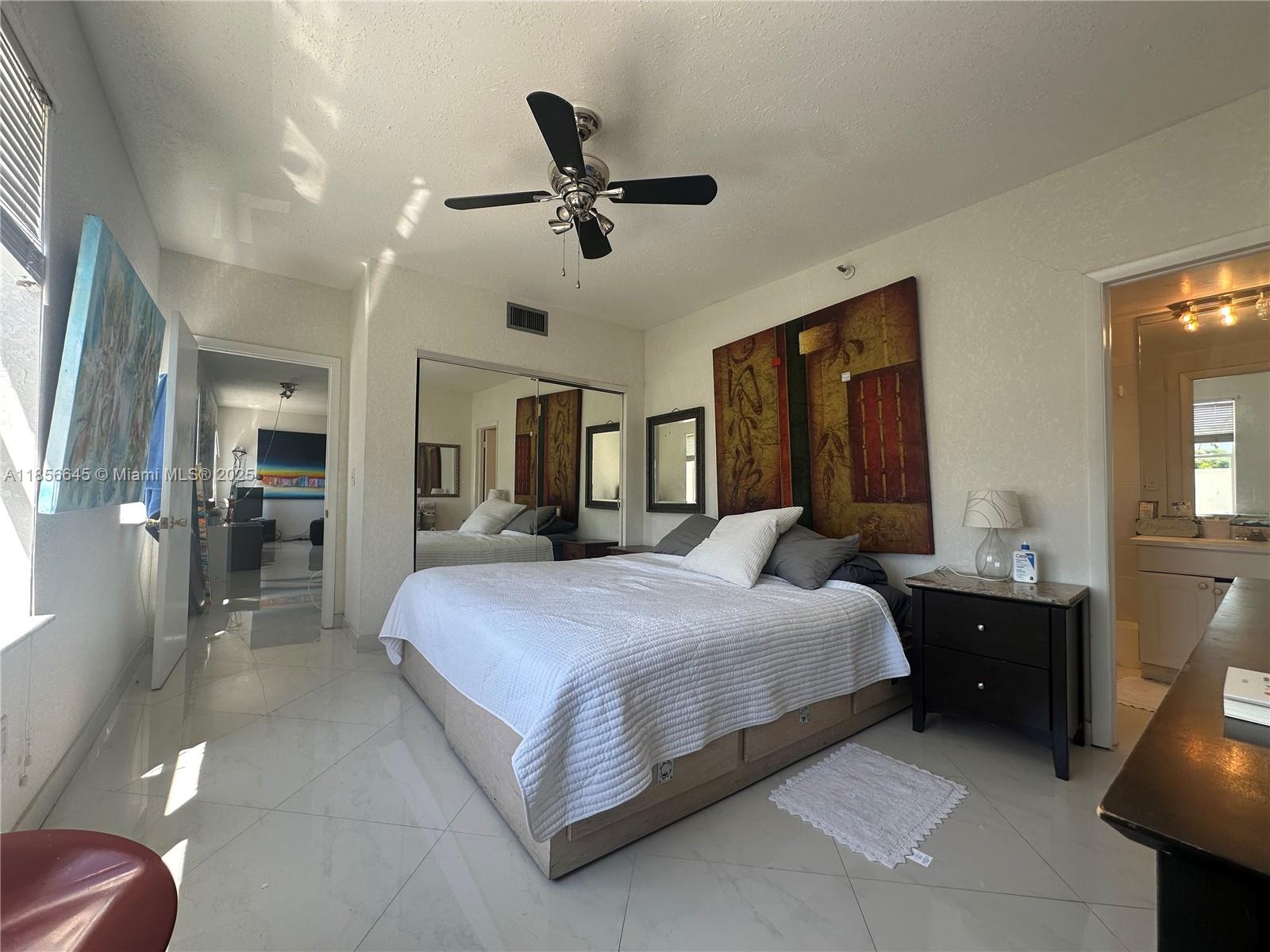 802 Euclid Avenue, Unit 305 Miami Beach, FL 33139 - Photo 12 of 13 a bedroom with a bed and a chandelier