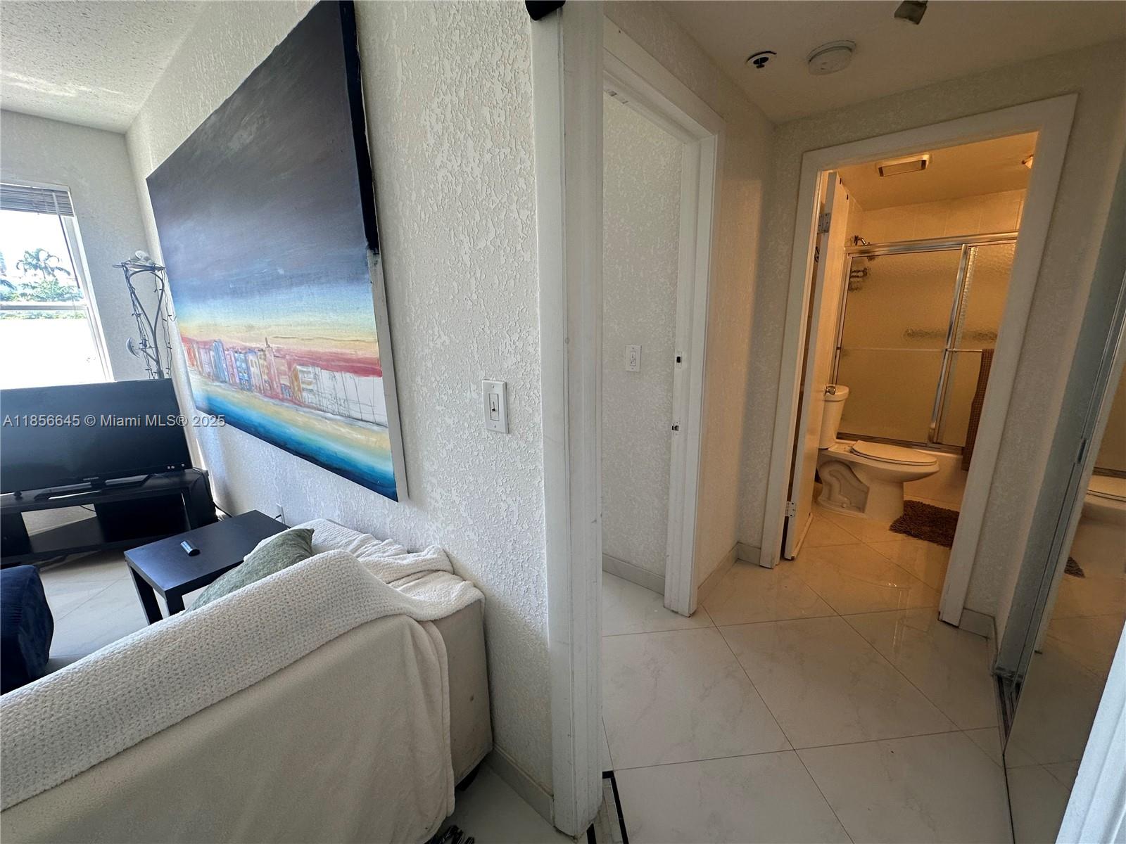 802 Euclid Avenue, Unit 305 Miami Beach, FL 33139 - Photo 3 of 13 a bedroom with a bed and a flat screen tv