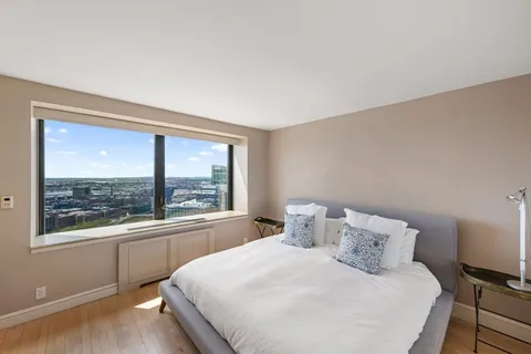 a bedroom with a bed and a large window