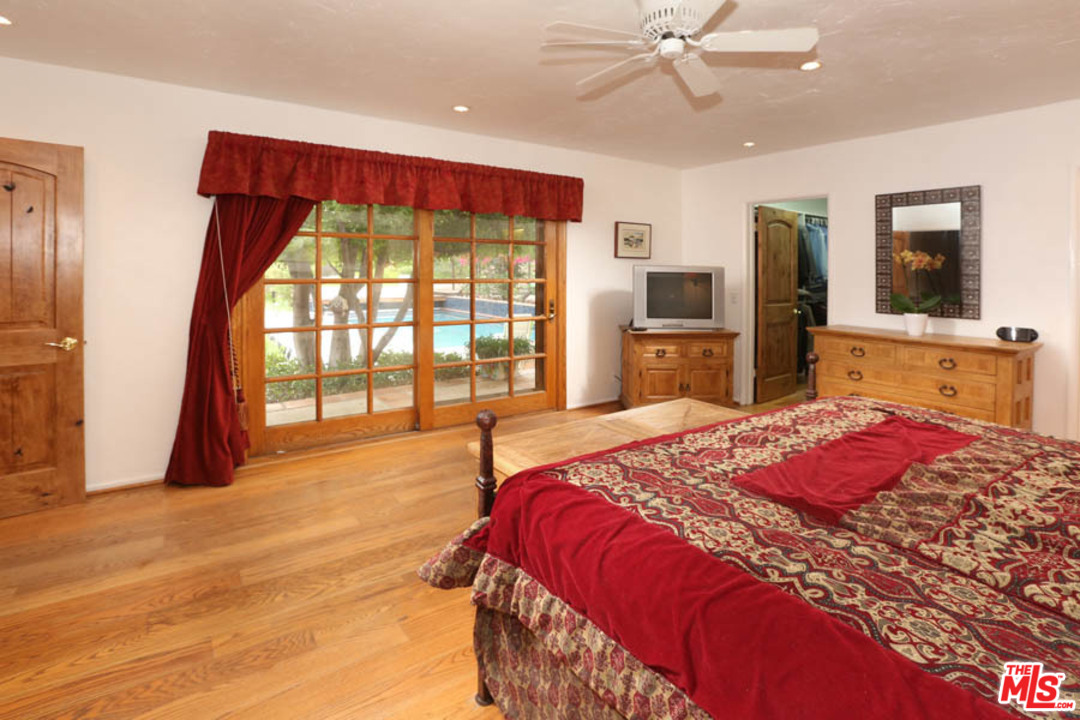 11345 Riverwood Drive Tujunga, CA 91042 - Photo 16 of 54 a bedroom with a large bed and a flat tv screen