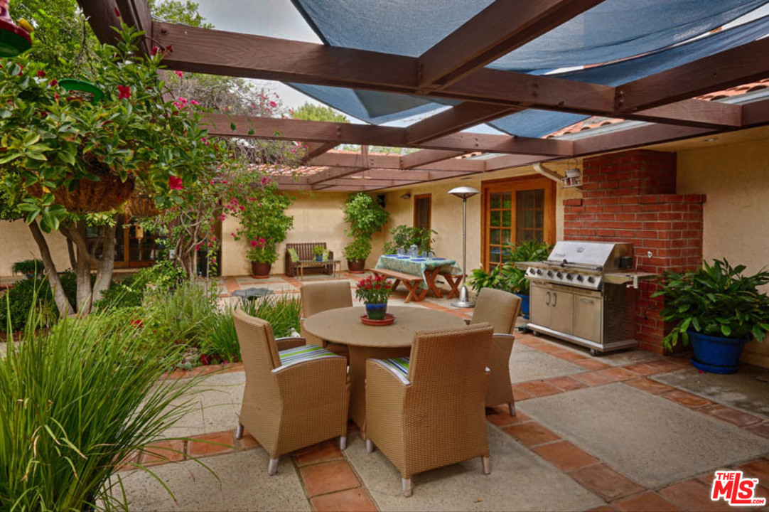 11345 Riverwood Drive Tujunga, CA 91042 - Photo 19 of 54 a view of a patio with table and chairs potted plants with floor to ceiling window and potted plants