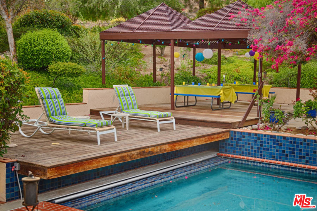 11345 Riverwood Drive Tujunga, CA 91042 - Photo 21 of 54 a view of a patio with a table chairs and a backyard