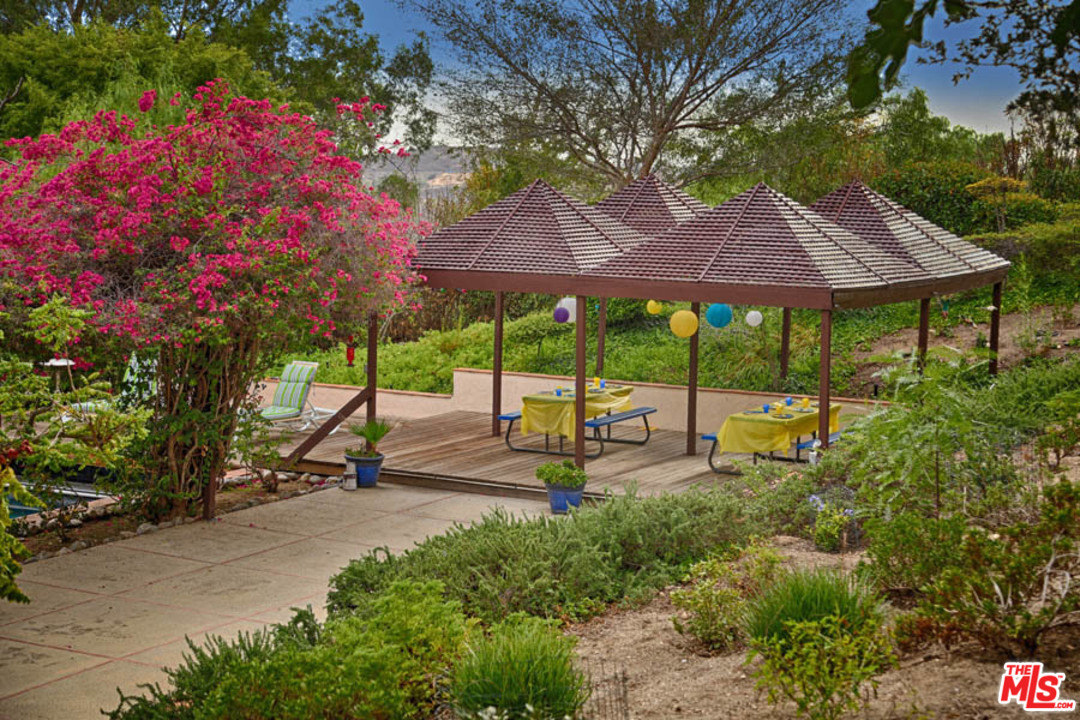 11345 Riverwood Drive Tujunga, CA 91042 - Photo 28 of 54 a view of a patio with table and chairs under an umbrella with a tree