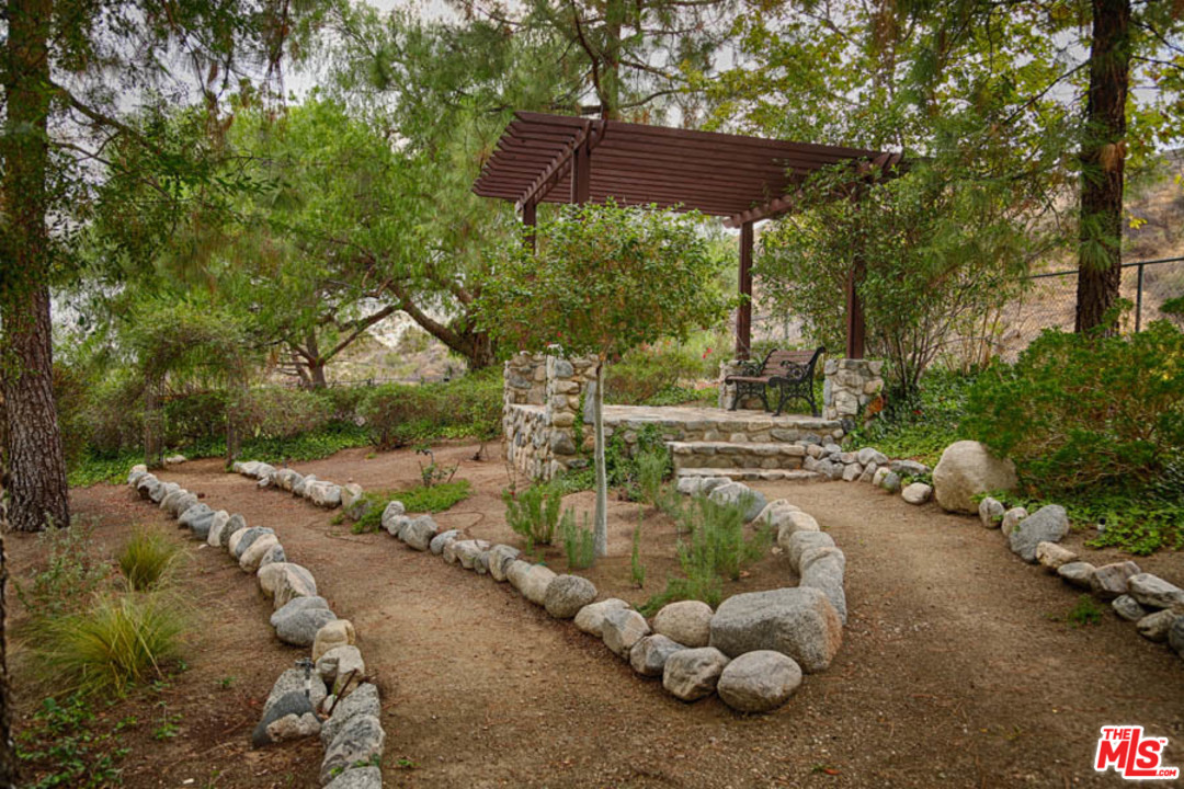 11345 Riverwood Drive Tujunga, CA 91042 - Photo 31 of 54 a view of a backyard with table and chairs under an umbrella