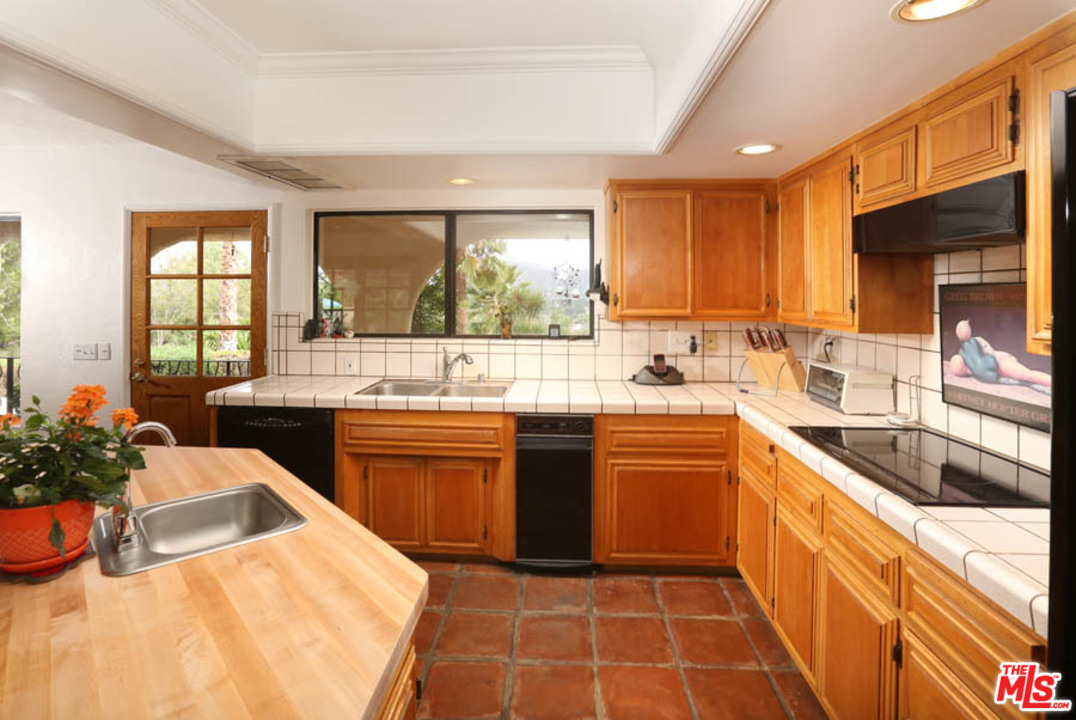 11345 Riverwood Drive Tujunga, CA 91042 - Photo 5 of 54 a kitchen with stainless steel appliances kitchen island granite countertop a sink and dishwasher a stove top oven with wooden floor