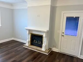 a view of a livingroom with wooden floor and a fireplace