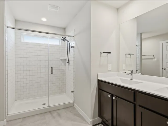 a bathroom with a shower sink and mirror
