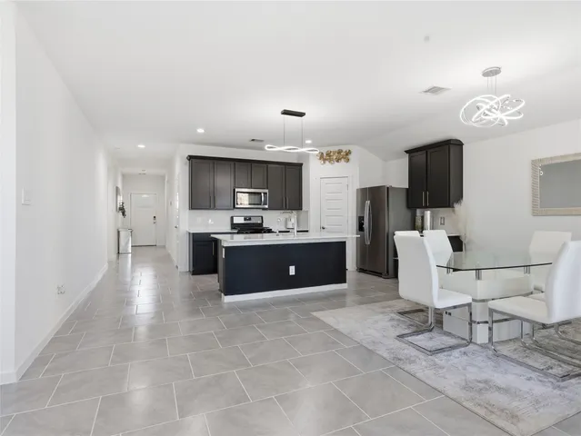 a large white kitchen with a large window and stainless steel appliances