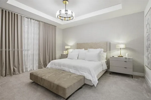 a spacious bedroom with a bed and a chandelier
