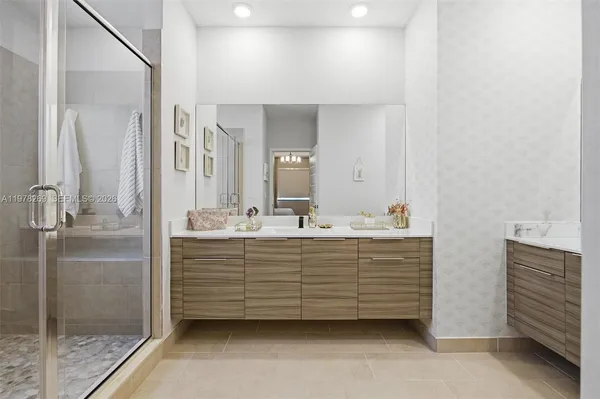 a bathroom with a sink mirror and shower