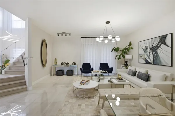 a living room with furniture a chandelier and a mirror