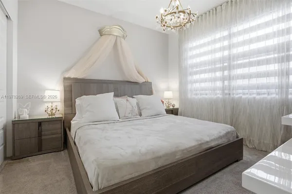 a bedroom with a bed and a chandelier