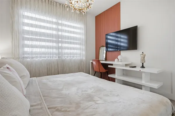 a bedroom with a bed and flat screen tv