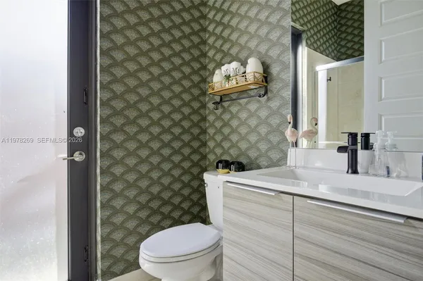 a bathroom with a sink mirror vanity and toilet