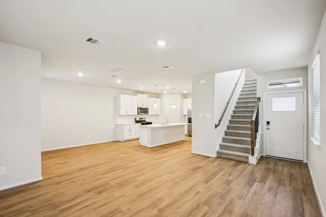a view of a kitchen with wooden floor and stairs