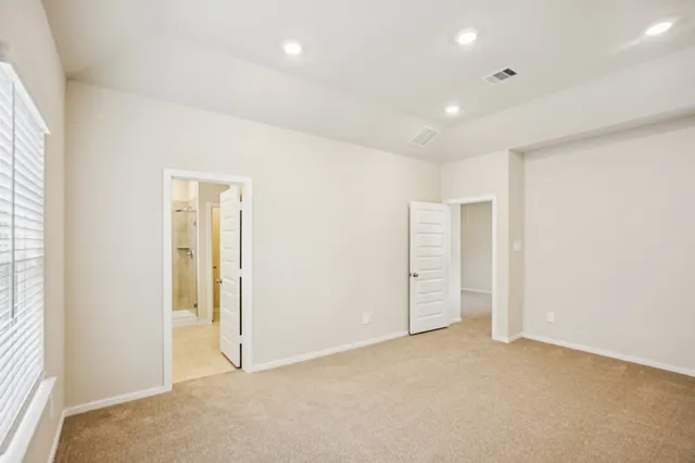 an empty room with closet and windows