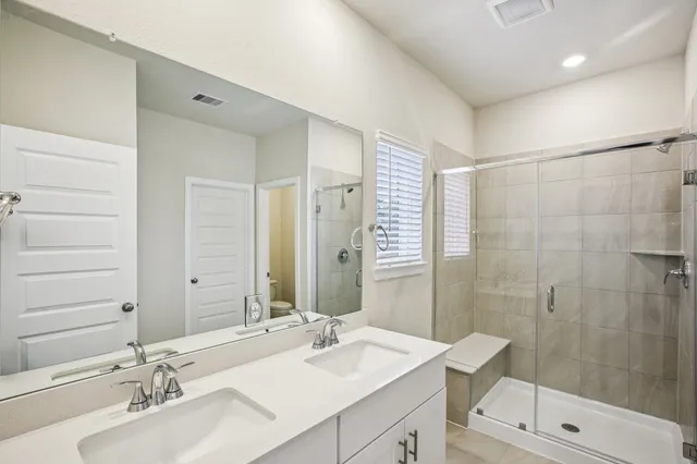 a bathroom with a sink double vanity and shower