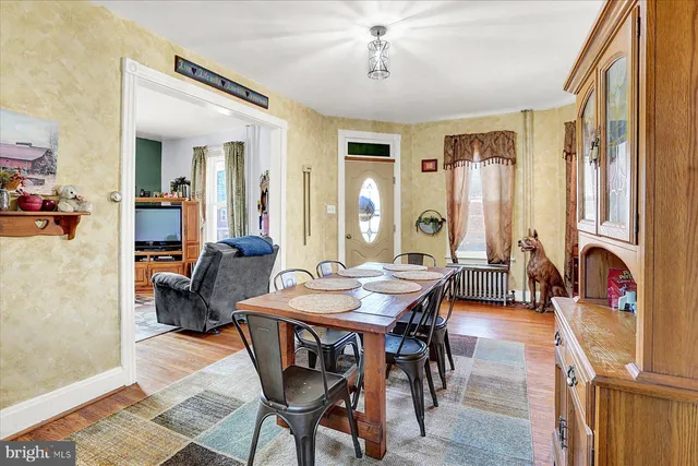 a view of a a dining room with furniture window and wooden floor