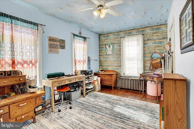 a view of a workspace with furniture and a window