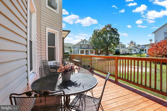 a backyard of a house with wooden floor barbeque oven and outdoor seating