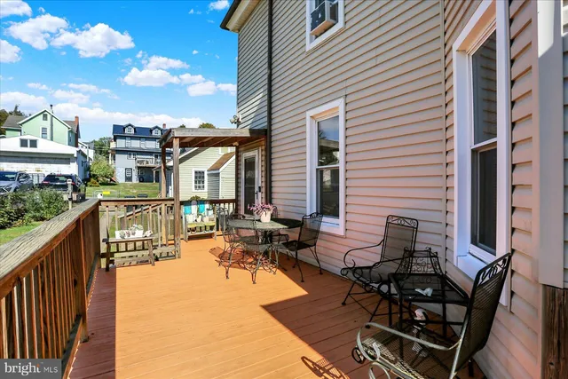 a balcony with wooden floor table and chairs