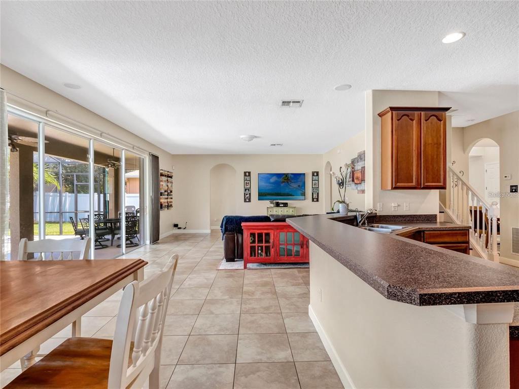 10023 Ians Ridge Road Orlando, FL 32832 - Photo 15 of 60 a large kitchen with kitchen island a large counter top space a sink and stainless steel appliances