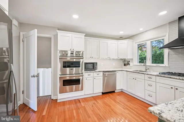 a kitchen with stainless steel appliances granite countertop a refrigerator and a sink