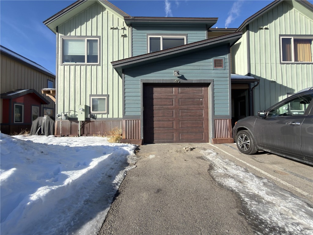 View of front facade with a garage and board and batten siding